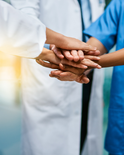 Healthcare professionals stacking hands