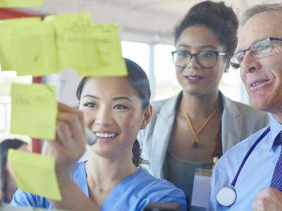 Pictured: A small group collaborating on a board with sticky notes