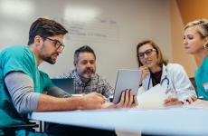 A four-person team looking at a notebook