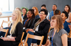 Pictured: A small audience smiling at an unseen presenter 