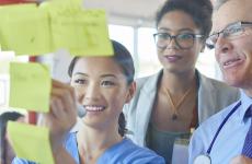 Pictured: A small group collaborating on a board with sticky notes