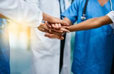 Healthcare professionals stacking hands