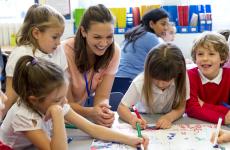 Teacher working with smiling young students