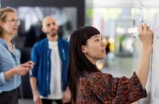 Photo of colleagues working at whiteboard