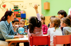 Photo of a young student raising her hand during a lesson