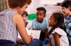 Photo of teacher reading to young students