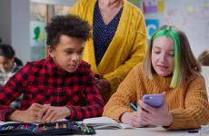 Teacher notice teen students using smartphone during lesson in class stock photo