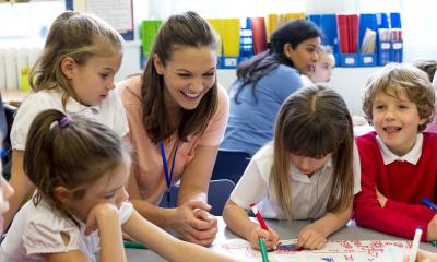 Teacher working with smiling young students