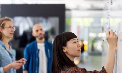 Photo of colleagues working at whiteboard