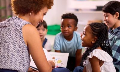 Photo of teacher reading to young students