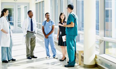 Healthcare professionals meeting in hospital hallway