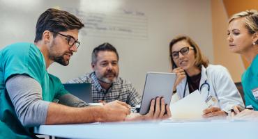 A four-person team looking at a notebook