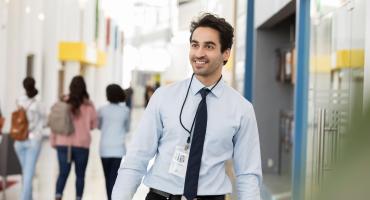 Smiling educator in hallway of students