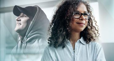 Photo of two people, one a smiling person in a hooded sweatshirt and the other in a dress shirt.