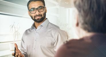 Photo of a professional speaking to a colleague