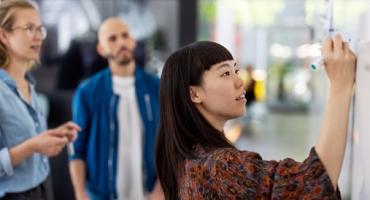 Photo of colleagues working at whiteboard