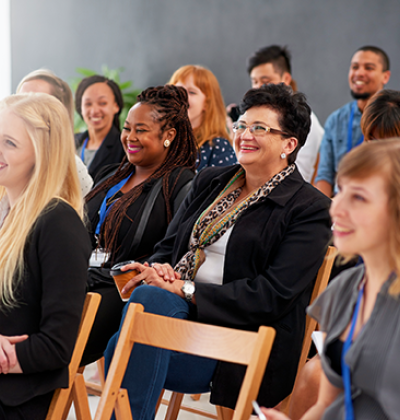 Pictured: A small audience smiling at an unseen presenter