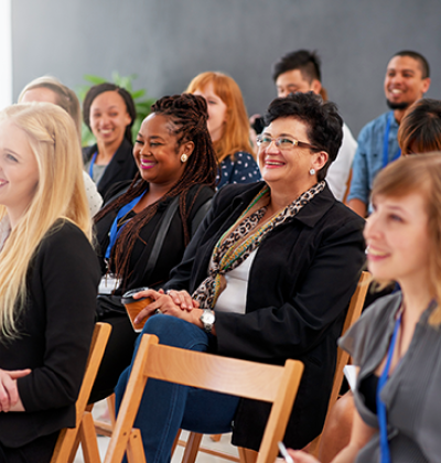 Pictured: A small audience smiling at an unseen presenter 