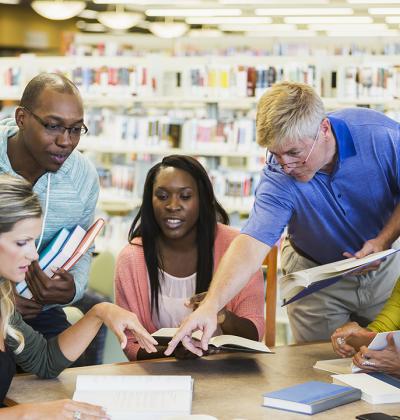 Education professionals conversing in library