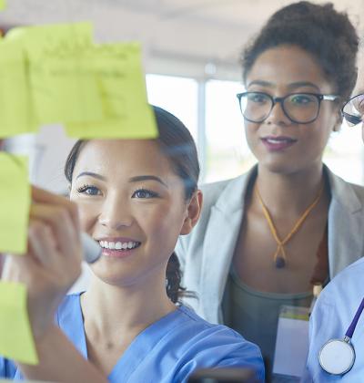 Pictured: A small group collaborating on a board with sticky notes