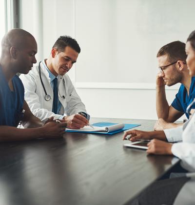 Pictured: A small group of healthcare workers collaborating at a conference room table