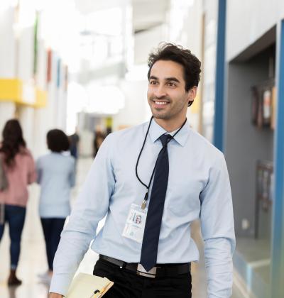 Smiling educator in hallway of students