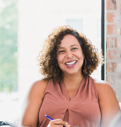 Professional with clipboard smiling in meeting