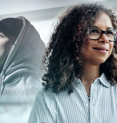 Photo of two people, one a smiling person in a hooded sweatshirt and the other in a dress shirt.