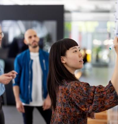 Photo of colleagues working at whiteboard