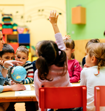 Photo of a young student raising her hand during a lesson