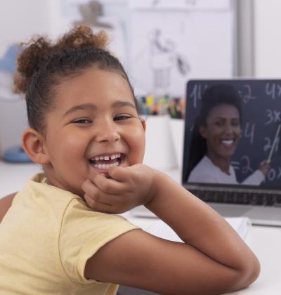 Smiling child learning on laptop
