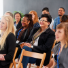 Pictured: A small audience smiling at an unseen presenter 