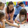 Teacher working with smiling young students